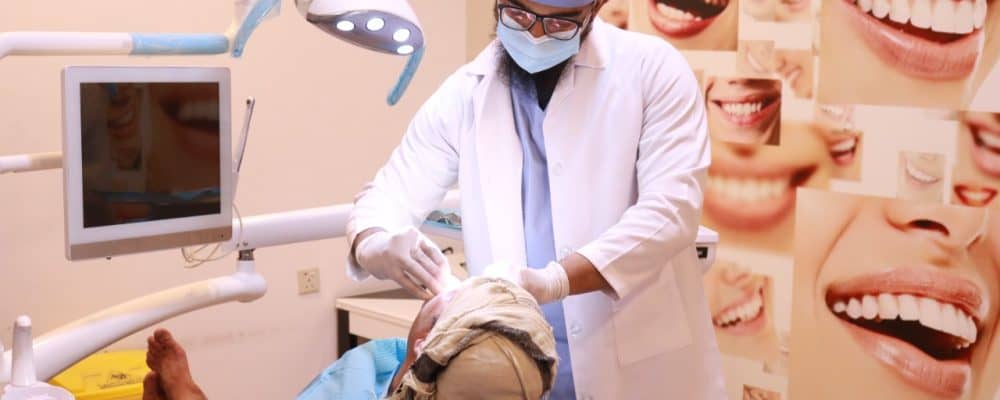Dentist Dr. Muhammad Rabi treating the patient with dental services