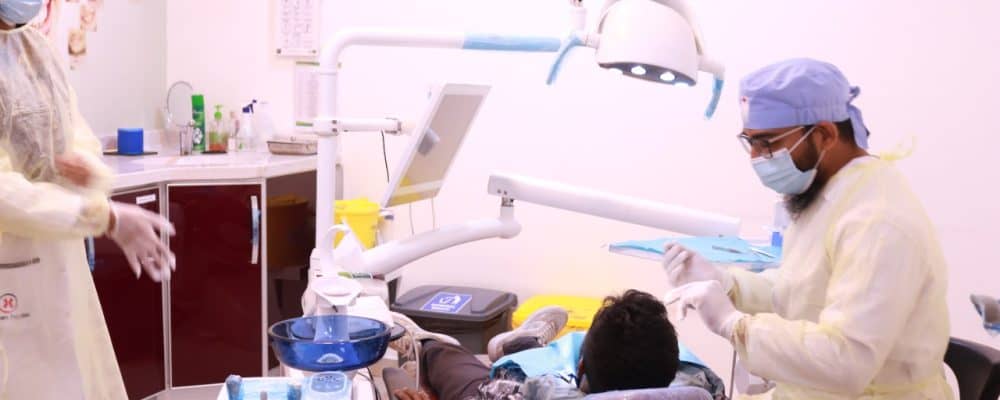 Dentist Dr. Muhammad Rabi treating the patient with dental services
